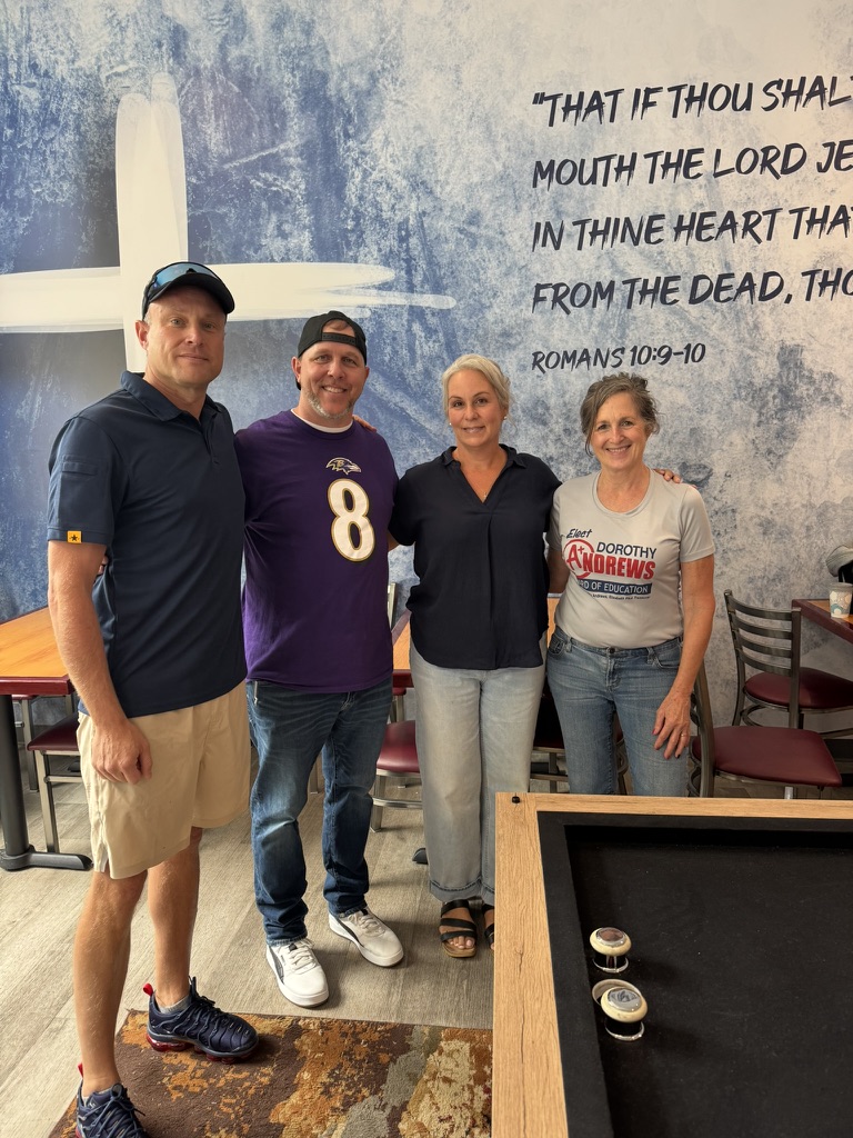 Four community members posing together at a gathering