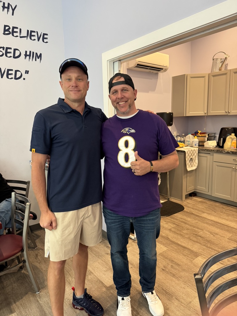 Two community members posing together beside the kitchen